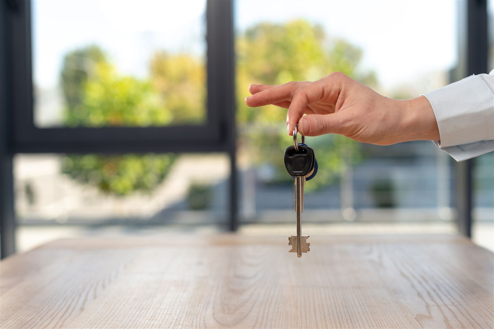 House keys being handed over across a desk